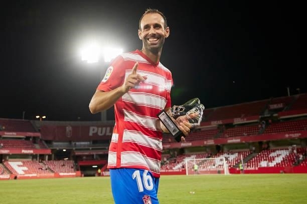 Victor Diaz of Granada CF poses with the trophy after the Ciudad de Granada trophy match between Granada CF and Malaga CF at Nuevo Los Carmenes...