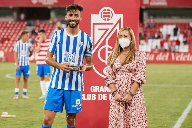 Juan de Dios Rivas 'Juande' of Malaga CF receives the runner-up award from Granada CF CEO Patricia Rodriguez after the Ciudad de Granada trophy match...