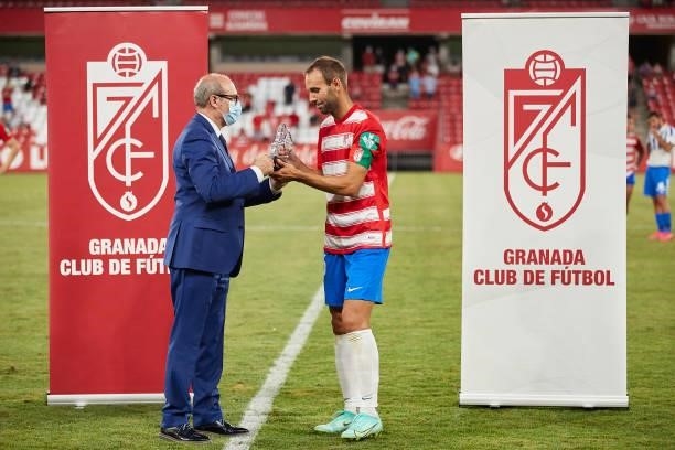 The acting mayor Jose Maria Corpas presents the trophy to the captain of Granada CF Victor Diaz after the Ciudad de Granada trophy match between...