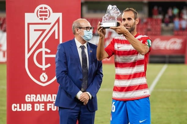 The acting mayor Jose Maria Corpas presents the trophy to the captain of Granada CF Victor Diaz after the Ciudad de Granada trophy match between...