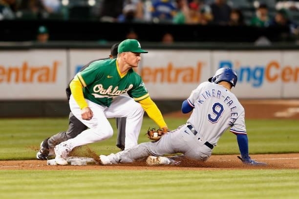 Isiah Kiner-Falefa of the Texas Rangers is tagged out by Matt Chapman of the Oakland Athletics while trying to steal third base in the top of the...