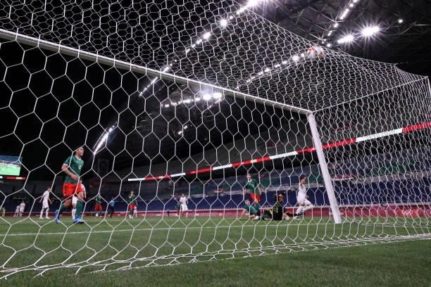 Kaoru Mitoma of Team Japan scores their side's first goal past Guillermo Ochoa of Team Mexico during the Men's Bronze Medal Match between Mexico and...