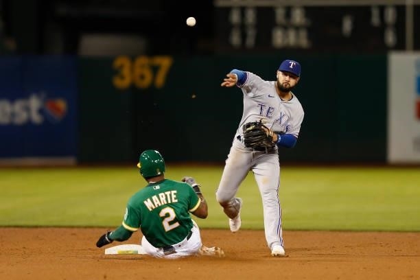 Isiah Kiner-Falefa of the Texas Rangers gets the out at second base of Starling Marte of the Oakland Athletics snd turns a double play in the bottom...