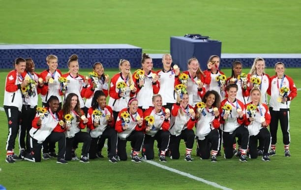 Team Canada poses with their medals after defeating Team Sweden during the women's football gold medal match between Canada and Sweden on day...
