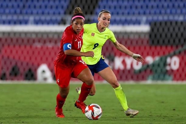 Desiree Scott of Team Canada competes for the ball with Kosovare Asllani of Team Sweden during the Olympic women's football gold medal match between...