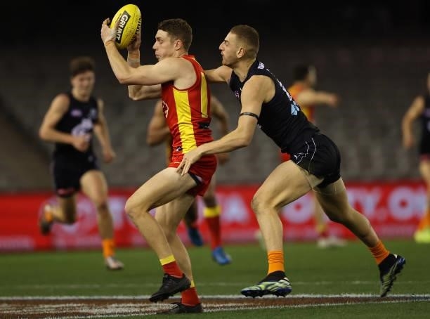 Josh Corbett of the Suns is challenged by Liam Jones of the Blues during the round 21 AFL match between Carlton Blues and Gold Coast Suns at Marvel...