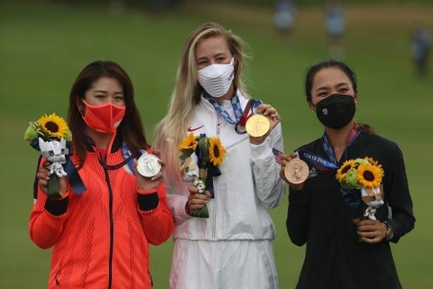 Mone Inami of Team Japan celebrates with the silver medal, Nelly Korda of Team United States celebrates with the gold medal and Lydia Ko of Team New...