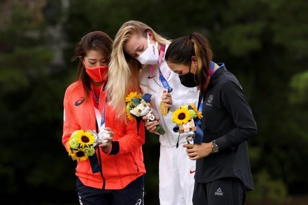 Silver medalist Mone Inami of Team Japan, gold medalist Nelly Korda of Team United States and bronze medalist Lydia Ko of Team New Zealand looks at...
