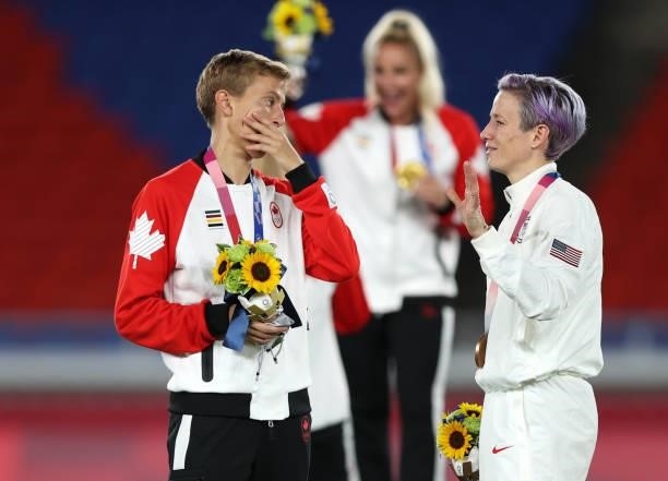 Gold medalist Quinn of Team Canada speaks with Megan Rapinoe of Team USA after winning the gold medal after becoming the first openly transgender...