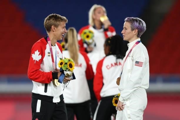 Gold medalist Quinn of Team Canada speaks with Megan Rapinoe of Team USA after winning the gold medal after becoming the first openly transgender...