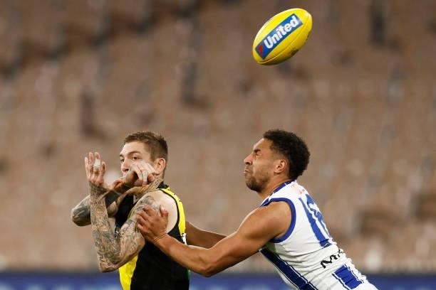 Matthew Parker of the Tigers handballs under pressure from Aiden Bonar of the Kangaroos during the round 21 AFL match between Richmond Tigers and...