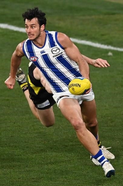 Robbie Tarrant of the Kangaroos handballs whilst being tackled during the round 21 AFL match between Richmond Tigers and North Melbourne Kangaroos at...