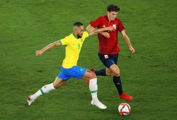 Matheus Cunha of Team Brazil battles for possession with Pau Torres of Team Spain during the Men's Gold Medal Match between Brazil and Spain on day...
