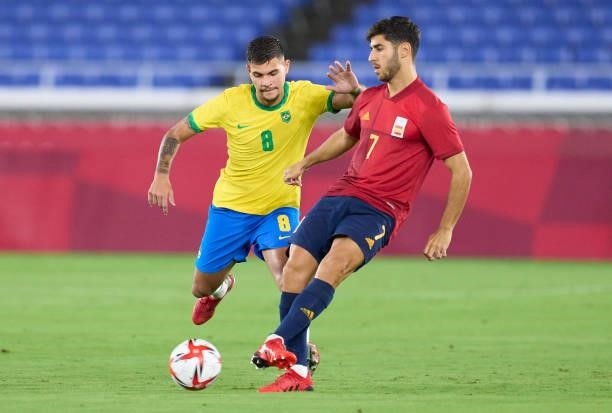 Bruno Guimaraes of Brazil competes for the ball with Marco Asensio of Spain during the Men's Gold Medal Match between Brazil and Spain on day fifteen...