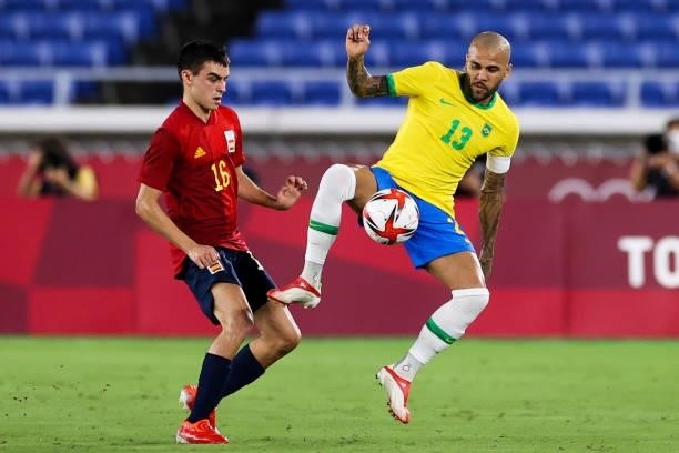 Dani Alves of Brazil competes for the ball with Pedri Gonzalez of Spain during the Men's Gold Medal Match between Brazil and Spain on day fifteen of...