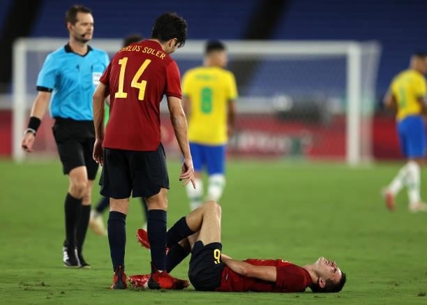 Pedri Gonzalez of Team Spain looks injured as Carlos Soler of Team Spain checks on him during the Men's Gold Medal Match between Brazil and Spain on...