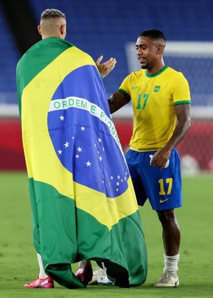 Richarlison of Team Brazil celebrates their side's victory with a flag of Brazil with team mate Malcom after the Men's Gold Medal Match between...