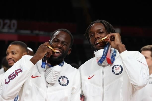 Draymond Green and Jerami Grant of Team United States bite their gold medals during the Men's Basketball medal ceremony on day fifteen of the Tokyo...