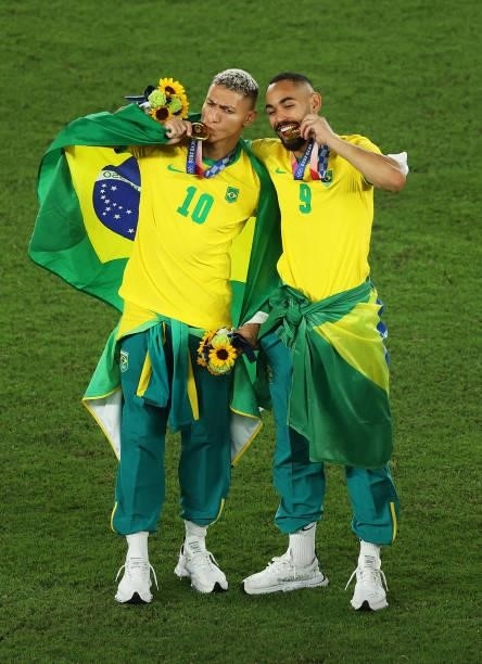 Gold medalists Richarlison and Matheus Cunha of Team Brazil pose with their gold medals during the Men's Football Competition Medal Ceremony on day...