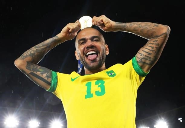Gold medalist Dani Alves of Team Brazil celebrates with their gold medal during the Men's Football Competition Medal Ceremony on day fifteen of the...