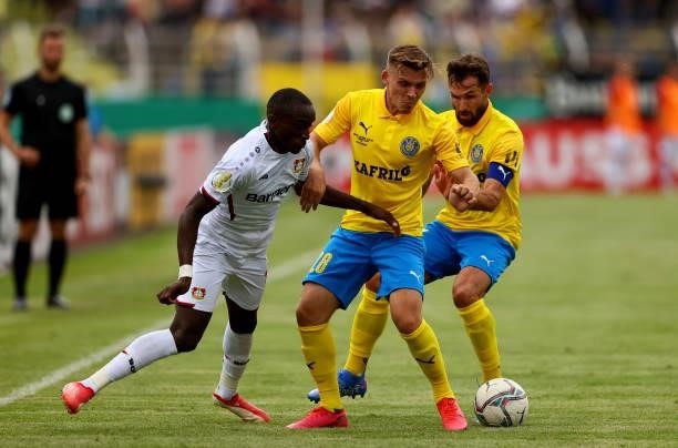 Damir Mehmedovic and Sascha Pfeffer of 1. FC Lok Leipzig challenge Moussa Diaby of Bayer Leverkusen during the DFB Cup first round match between 1....