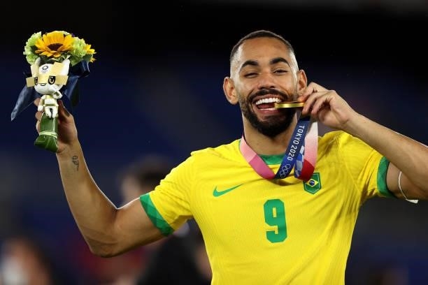 Gold medalist Matheus Cunha of Team Brazil celebrates with their gold medal during the Men's Football Competition Medal Ceremony on day fifteen of...