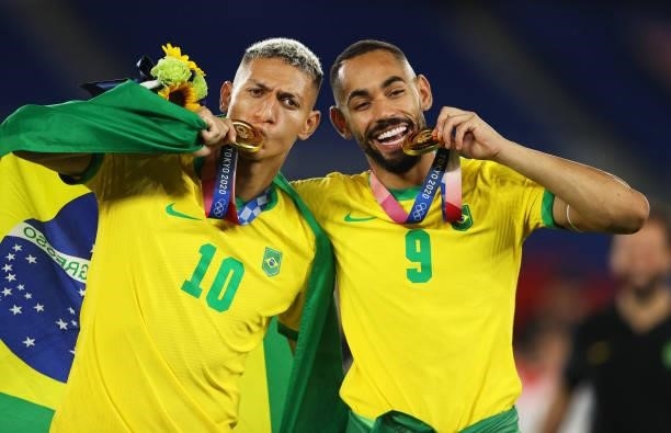 Gold medalists Richarlison and Matheus Cunha of Team Brazil celebrate with their gold medal during the Men's Football Competition Medal Ceremony on...