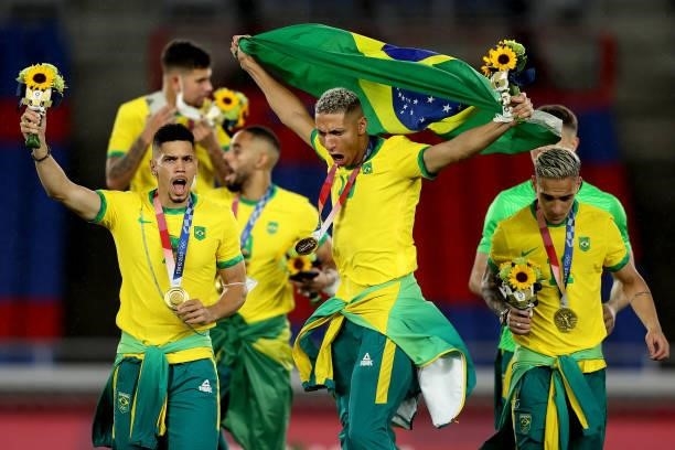 Gold medalists Paulinho, Richarlison and Antony of Team Brazil celebrate with their medals during the Men's Football Competition Medal Ceremony on...