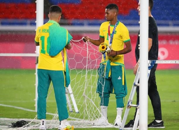 Henrique Matheus and Abner of Team Brazil attempt to cut a part of the net during the Men's Football Competition Medal Ceremony on day fifteen of the...