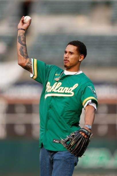 Player Juan Toscano-Anderson of the Golden State Warriors prepares to throw out the ceremonial first pitch before the game between the Oakland...
