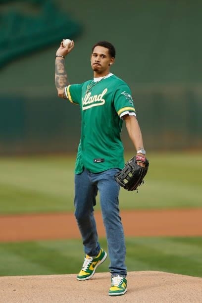 Player Juan Toscano-Anderson of the Golden State Warriors throws out the ceremonial first pitch before the game between the Oakland Athletics and the...