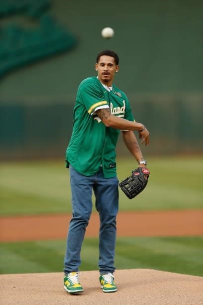 Player Juan Toscano-Anderson of the Golden State Warriors throws out the ceremonial first pitch before the game between the Oakland Athletics and the...