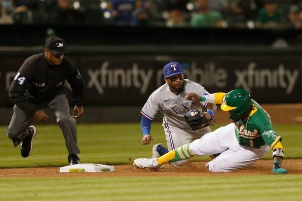Josh Harrison of the Oakland Athletics is tagged out at third base by Yonny Hernandez of the Texas Rangers in the bottom of the tenth inning at...