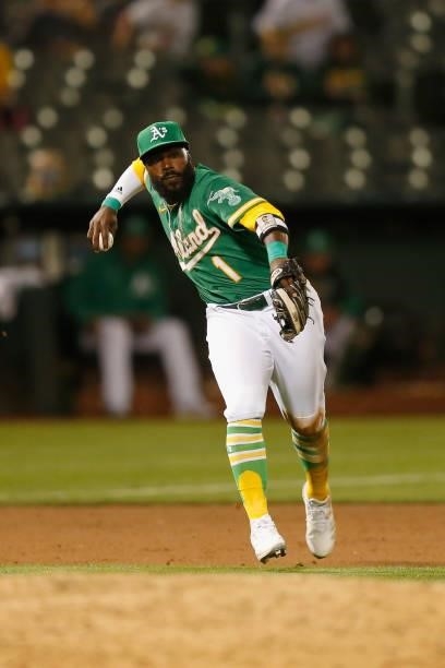 Josh Harrison of the Oakland Athletics fields the ball and throws to first base to get the out of Isiah Kiner-Falefa of the Texas Rangers in the top...