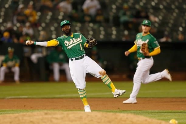 Josh Harrison of the Oakland Athletics fields the ball and throws to first base to get the out of Isiah Kiner-Falefa of the Texas Rangers in the top...