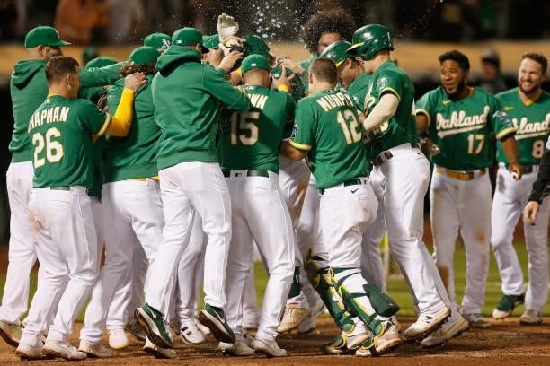 Starling Marte of the Oakland Athletics celebrates with teammates after hitting a walk-off three-run home run in the bottom of the eleventh inning...