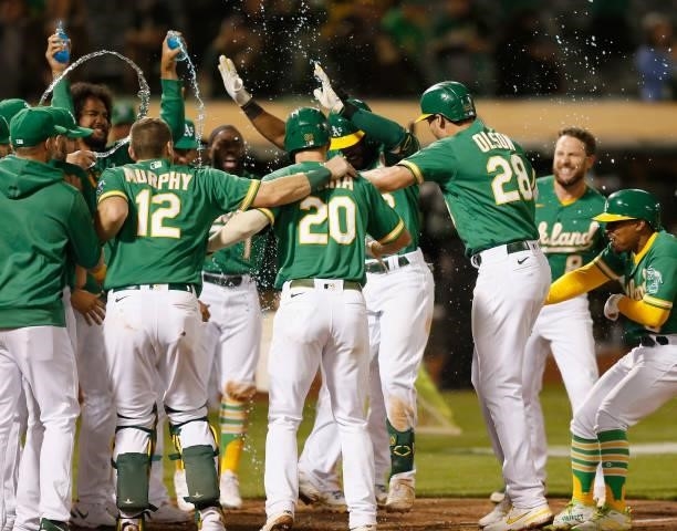 Starling Marte of the Oakland Athletics celebrates with teammates after hitting a walk-off three-run home run in the bottom of the eleventh inning...