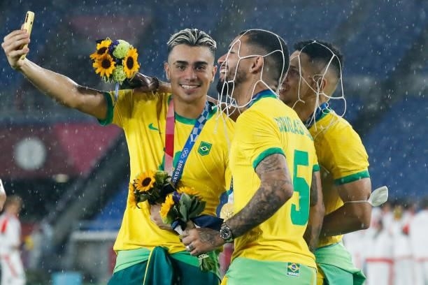 Matheus Henrique, Douglas Luiz, Paulinho of Brazil celebrates after the award ceremony of the Men's Gold Medal Match between Brazil and Spain on day...