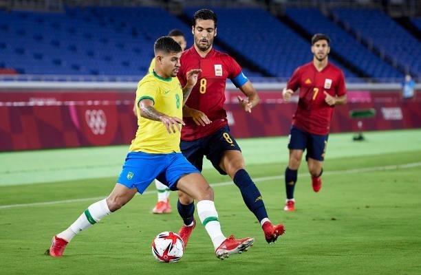 Bruno Guimaraes of Team Brazil competes for the ball with Mikel Merino of Team Spain during the Men's Gold Medal Match between Team Brazil and Team...