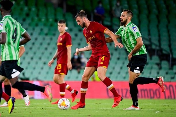 Bryan Cristante of S Roma is challenged by a Real Betis player during the Unbeatables Cup at Estadio Benito Villamarin on August 07, 2021 in Seville,...