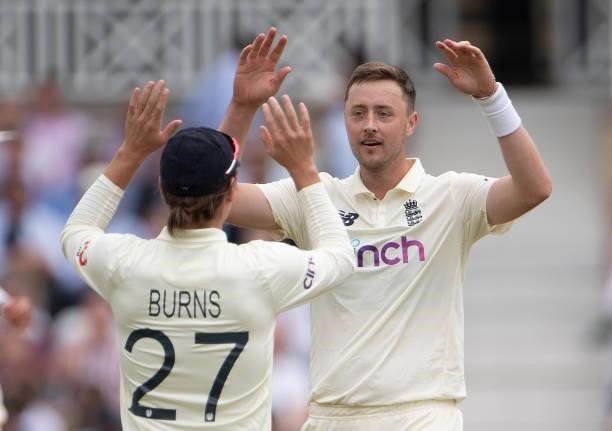 Ollie Robinson of England celebrates taking the wicket of Rohit Sharma of India with Rory Burns during day two of the First Test Match between...