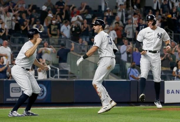 Joey Gallo of the New York Yankees celebrates his seventh inning three run home run against the Seattle Mariners with teammates Giancarlo Stanton and...