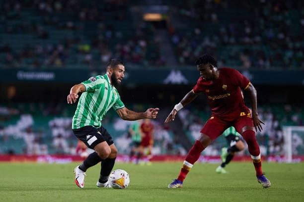 Nabil Fekir of Real Betis competes for the ball with Ebrima Darboe of AS Roma during a friendly match between Real Betis and AS Roma at Estadio...