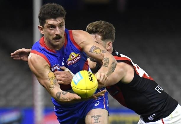 Tom Liberatore of the Bulldogs handballs whilst being tackled during the round 21 AFL match between Western Bulldogs and Essendon Bombers at Marvel...