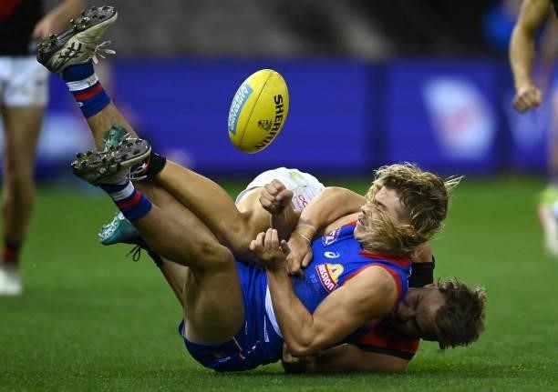 Bailey Smith of the Bulldogs handballs whilst being tackled by Matt Guelfi of the Bombers during the round 21 AFL match between Western Bulldogs and...