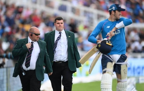 Craig Overton is escorted around the ground by security guards during day four of the First Test Match between England nd India at Trent Bridge on...