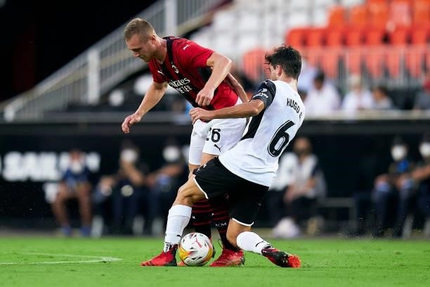 Hugo Guillamon of Valencia CF competes for the ball with Tommaso Pobega of AC Milan during a pre-season friendly match between Valencia CF and AC...