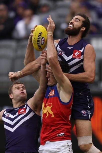 Oscar McInerney of the Lions marks the ball against Sean Darcy and Alex Pearce of the Dockers during the round 21 AFL match between Fremantle Dockers...