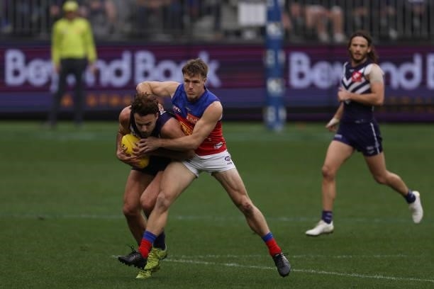 Griffin Logue of the Dockers gets tackled by Lincoln McCarthy of the Lions during the round 21 AFL match between Fremantle Dockers and Brisbane Lions...