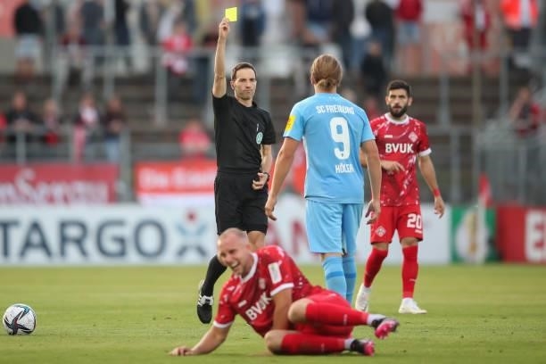 Lucas Hoeler of SC Freiburg is shown a yellow card by Referee Benjamin Brand during the DFB Cup first round match between Würzburger Kickers and SC...